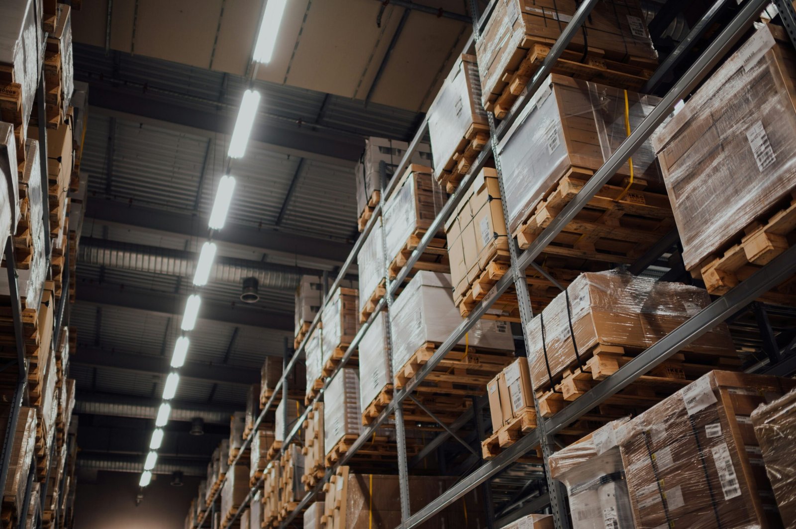 Industrial Warehouse Storage and Inventory System Interior of a large warehouse with tall storage racks filled with pallets and packaged goods, showcasing organized inventory and logistics storage operations.